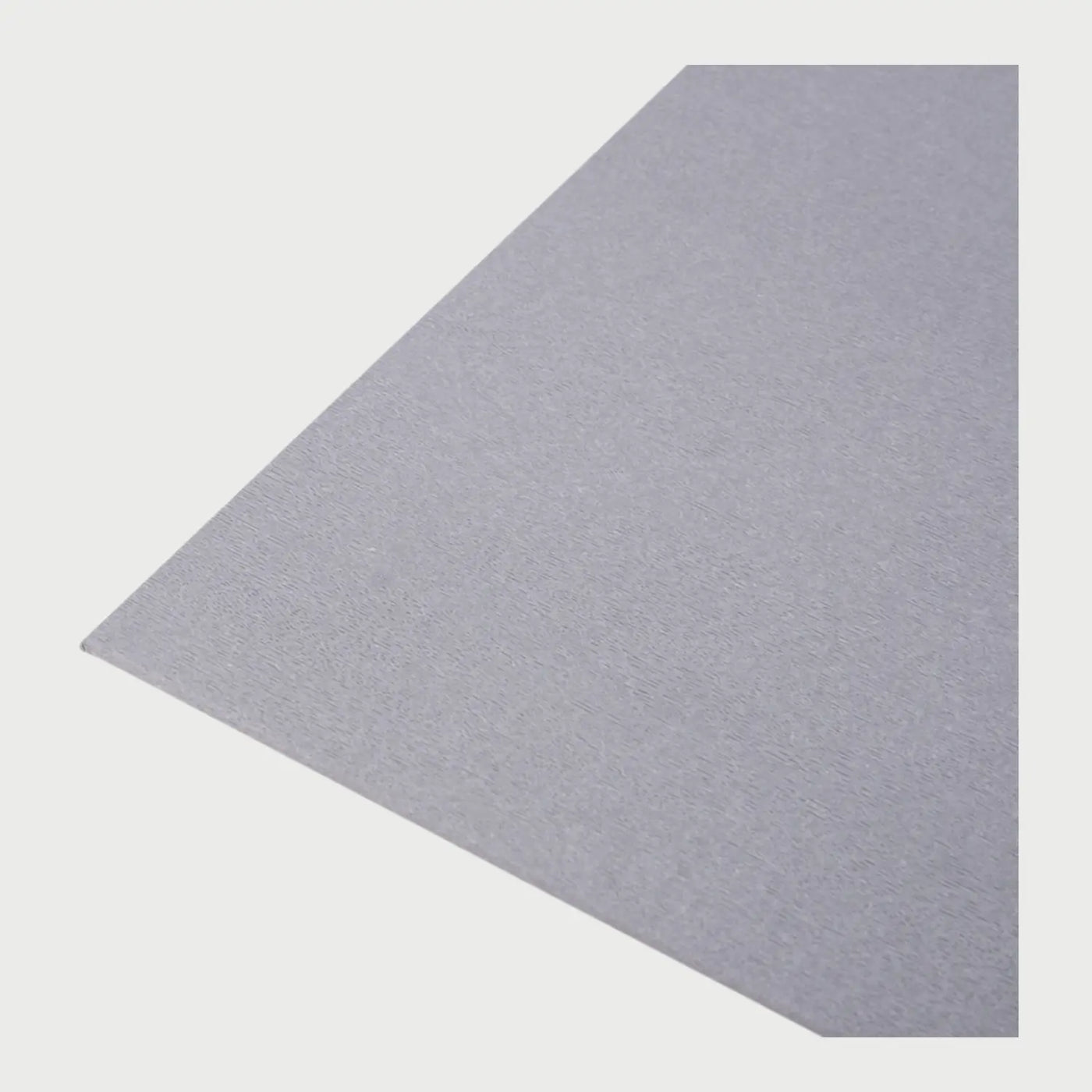 Perfil lateral de la almohadilla Puler gris, donde se aprecia su diseño ultra delgado y flexible que se adhiere perfectamente a superficies planas sin crear relieves incómodos.