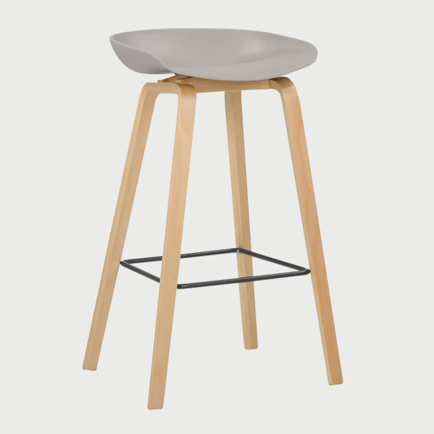 Vista lateral del banco alto Perique beige, mostrando la curvatura del asiento y la inclinación de sus patas de madera que proporcionan una base estable y un estilo de inspiración nórdica.