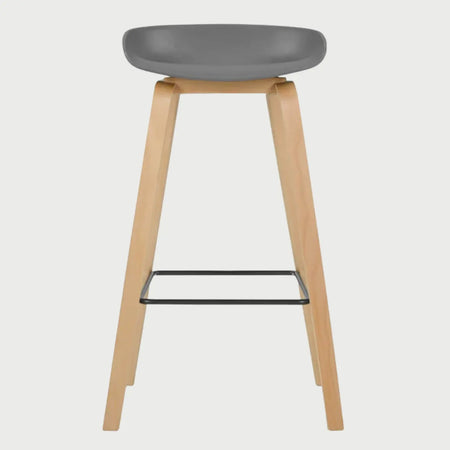 Vista frontal del banco alto Perique en color gris, destacando su silueta minimalista y el contraste entre el asiento sintético y las patas de madera clara.