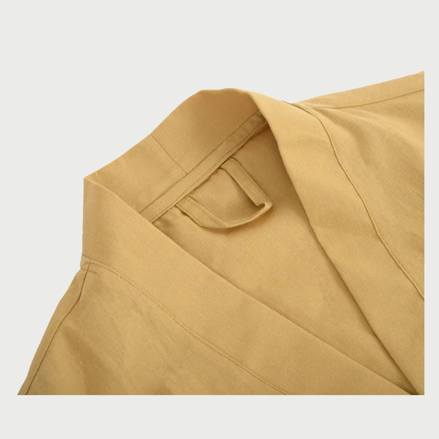 Perfil lateral de la bata Vanti beige en talla L/XL, resaltando la amplitud de las mangas y la caída fluida del tejido de algodón que llega por encima de la rodilla.