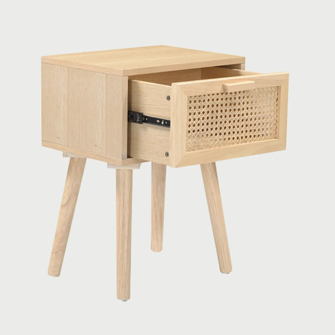 Vista lateral del buró Chemis, mostrando el cuerpo rectangular de madera clara y la inclinación de sus patas cónicas que le otorgan una silueta estilizada y ligera.