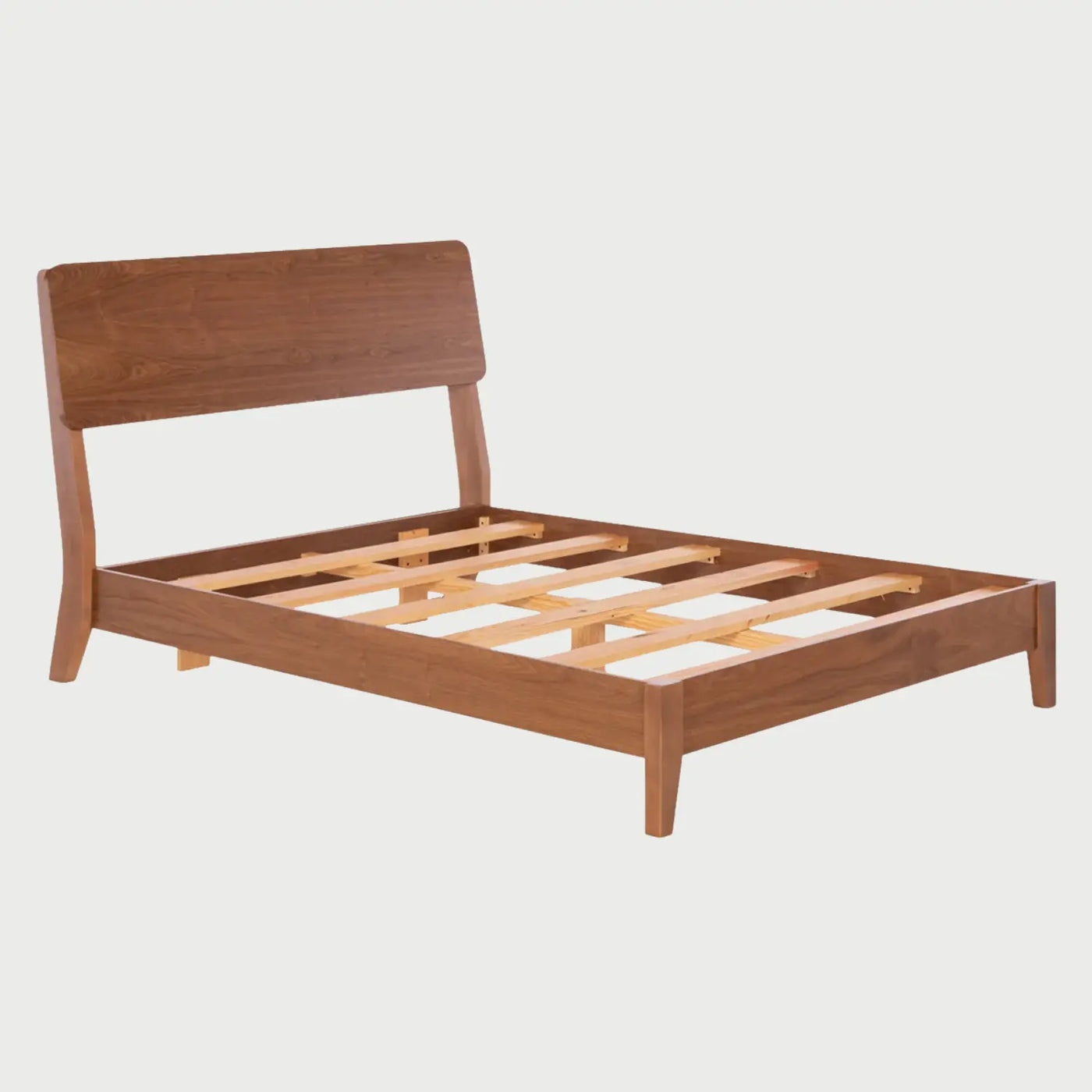 Vista interna de la cama Akari que muestra un sistema de somier compuesto por láminas de madera clara dispuestas horizontalmente, diseñado para proporcionar un soporte firme y ventilado al colchón.