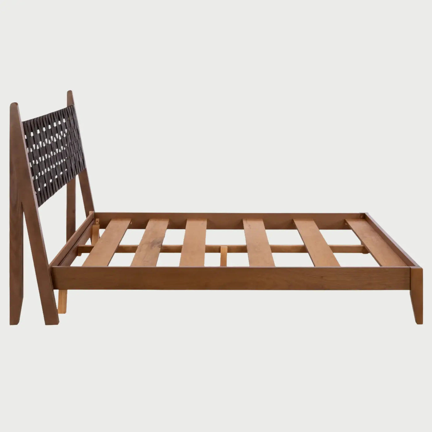 Vista de perfil de la cama Ami; se aprecia la inclinación ergonómica de la cabecera y la robustez de los largueros laterales de madera en tono café nogal que forman la base de perfil bajo.