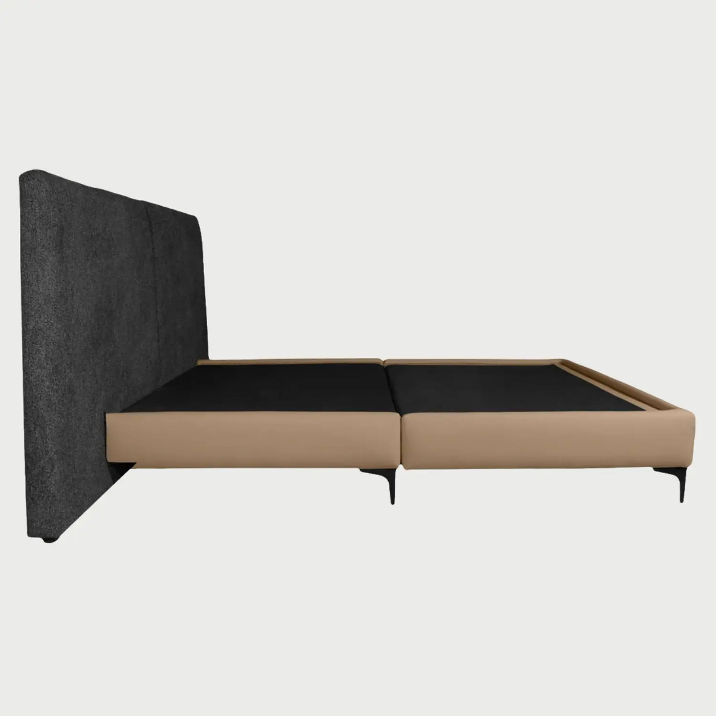 Vista del área de soporte de la cama Blake, mostrando la superficie interna en color negro diseñada para el apoyo del colchón, enmarcada por los laterales acolchados en color beige que definen su estructura moderna.