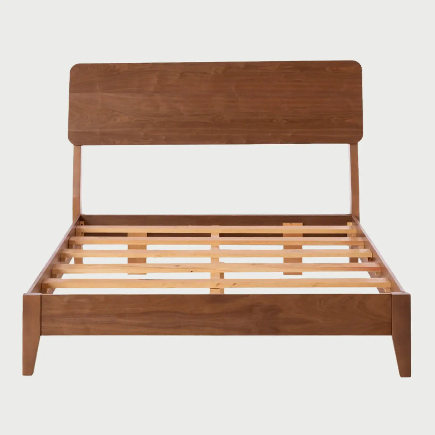 Vista frontal de la cama matrimonial Akari; presenta una estructura de madera con acabado nogal en tono café, destacando una cabecera rectangular de bordes suavizados y una base de perfil bajo con patas angulares discretas.