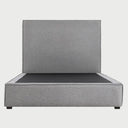 Vista frontal de la cama matrimonial Raquel en color gris medio; ofrece un equilibrio visual perfecto que destaca la estructura envolvente de la base y la altura de su respaldo liso.