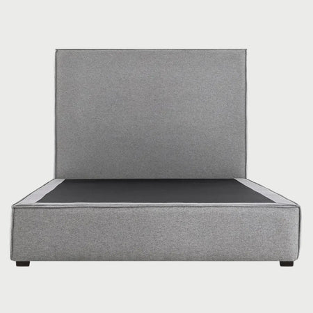 Vista frontal de la cama matrimonial Raquel en color gris medio; ofrece un equilibrio visual perfecto que destaca la estructura envolvente de la base y la altura de su respaldo liso.