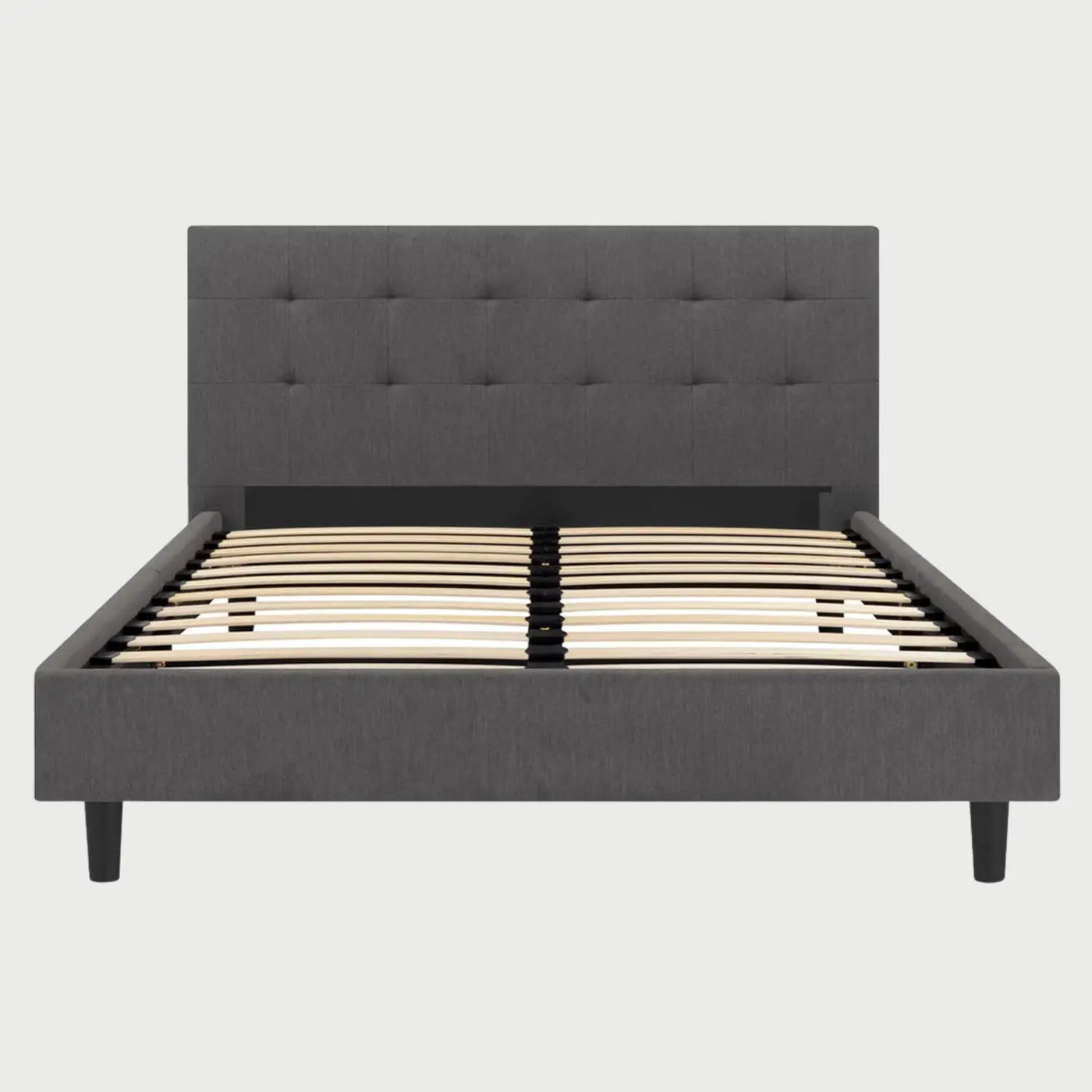 Vista frontal de la cama Queen Size Volpi; destaca una cabecera alta tapizada en tela gris oscuro con un elegante diseño de capitonado cuadrado que aporta textura y un estilo contemporáneo al dormitorio.