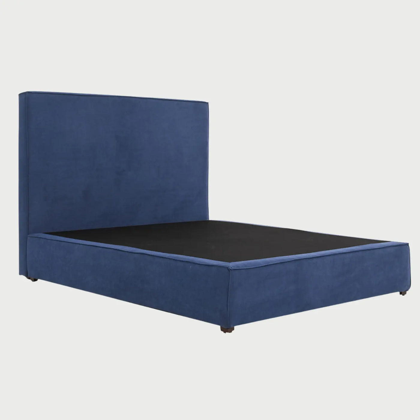 Vista de la superficie de soporte de la cama Raquel, mostrando el área interna oscura donde se apoya el colchón, rodeada por el marco tapizado en azul que define su silueta contemporánea