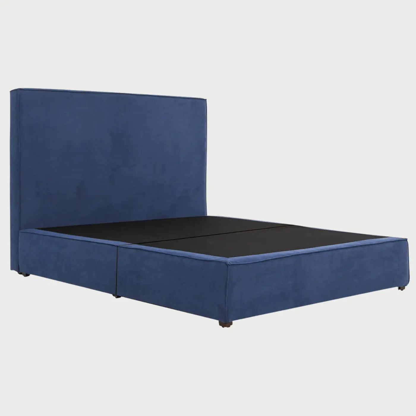 Vista lateral de la cama Raquel en color azul; se aprecia la estructura envolvente de la base acolchada y la profundidad de la cabecera, resaltando una silueta limpia sin patas visibles que descansa casi a ras de suelo.