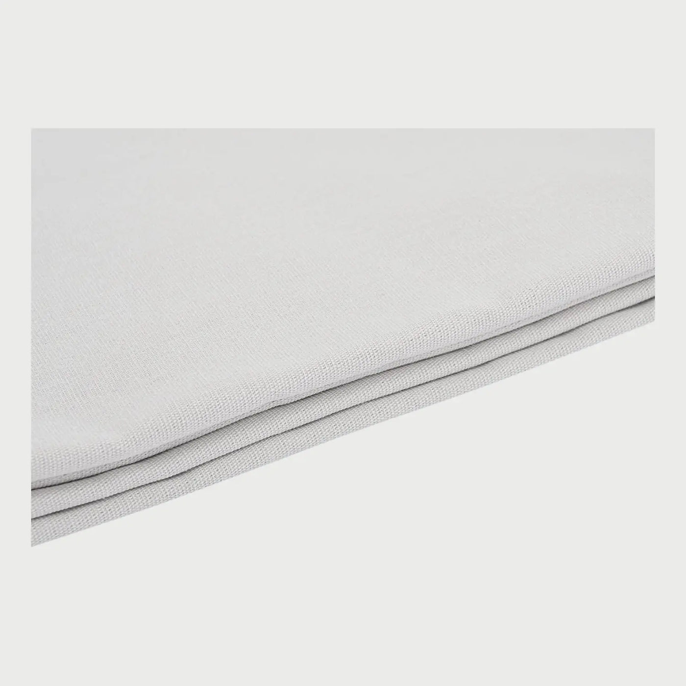 Acercamiento a la textura del camino de mesa Bavicanora en color gris claro; se observa el tejido de trama cerrada con un acabado que emula la frescura del lino y el detalle del doblez lateral con costuras precisas.