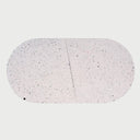 Vista frontal superior de la charola grande Moat; presenta una forma ovalada dividida en dos módulos simétricos de concreto blanco, decorados con un sutil patrón de puntos oscuros que brindan una estética tipo terrazo.