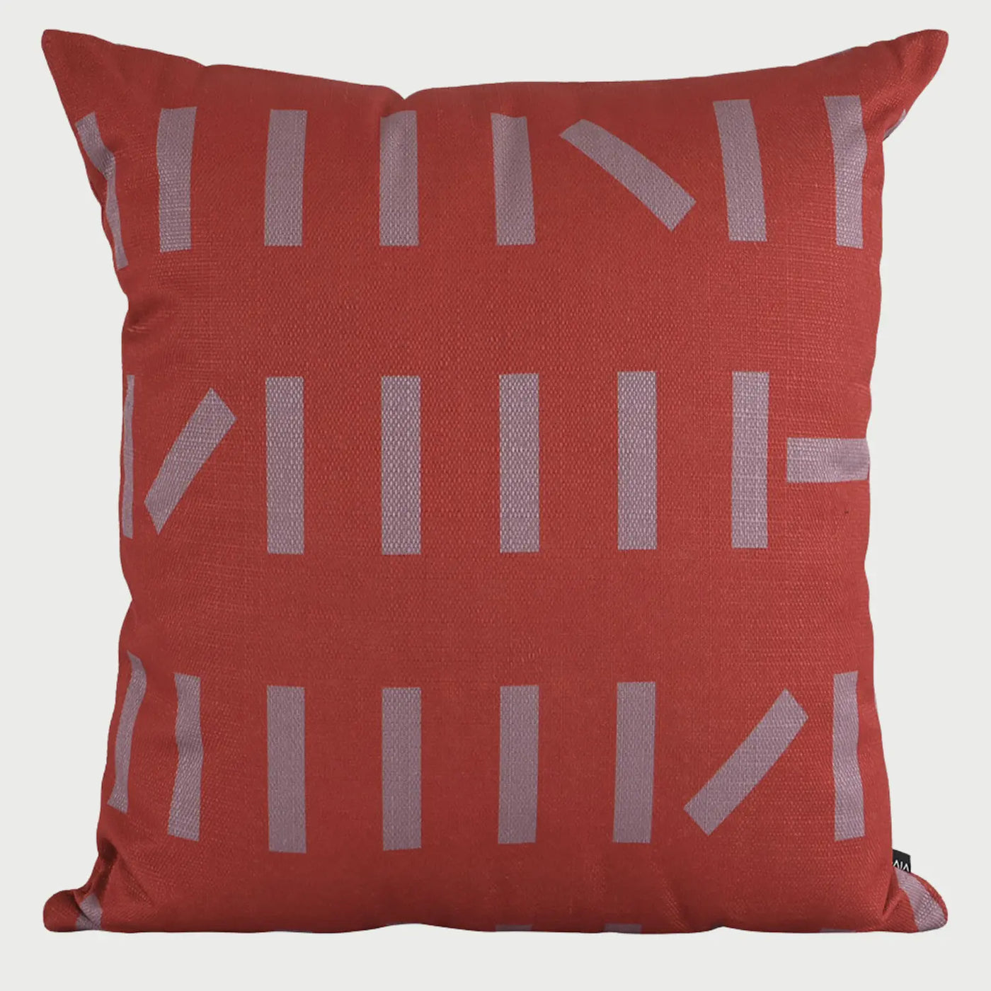 Vista frontal del cojín cuadrado Maica de 50 x 50 cm; presenta una base de tela en color rojo intenso decorada con un patrón LINEAs cortas y rectangulares en color gris pálido, dispuestas en filas horizontales con algunas inclinaciones aleatorias que crean un ritmo visual moderno.