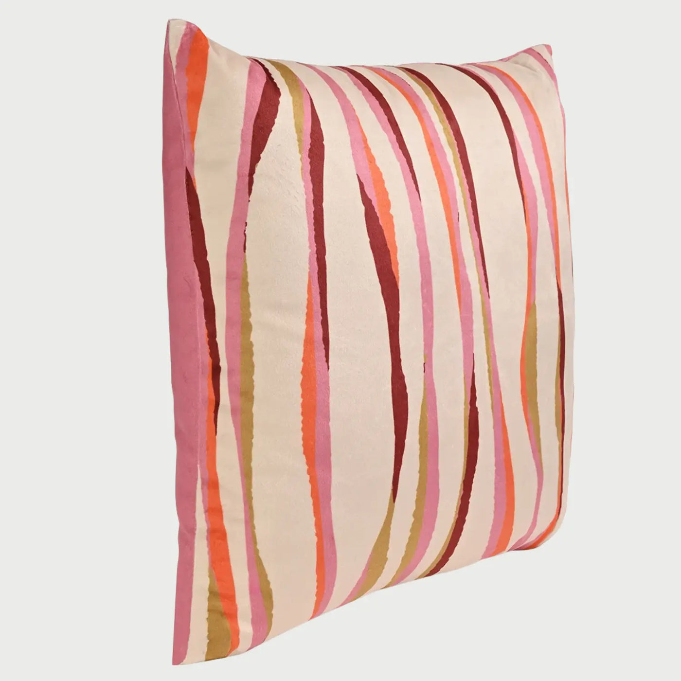 Vista lateral en ángulo del cojín cuadrado Serpentina de 50 x 50 cm; se observa su perfil con un relleno generoso que le otorga un volumen suave y redondeado. El costado muestra un acabado en rosa sólido, mientras que la cara principal presenta un patrón LINEAs verticales irregulares y onduladas en tonos rosa, naranja, borgoña y ocre sobre un fondo crema.