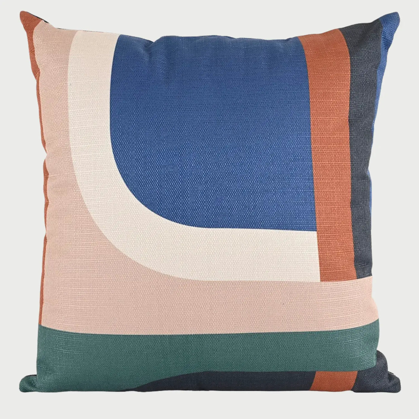 Vista frontal del cojín cuadrado Tayrona de 50 x 50 cm; presenta un diseño de bloques de color asimétricos con una gran forma curva en azul cobalto enmarcada por franjas en color crema, rosa pálido, terracota y verde bosque en la base.
