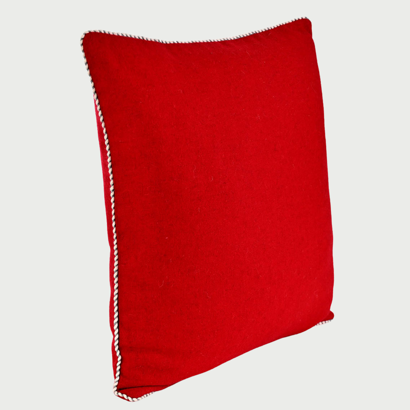 Vista lateral del cojín Víspera de 45 x 45 cm; se aprecia su estructura cuadrada con un relleno uniforme que proporciona volumen y soporte, destacando el detalle del cordón trenzado que recorre el borde de la pieza.