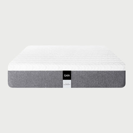 Vista frontal del colchón GAIA Plus Híbrido en tamaño Queen Size; presenta una superficie superior blanca con un patrón de tejido geométrico en relieve y una base lateral en tela gris con una etiqueta central distintiva que indica "GAIA Plus Support".