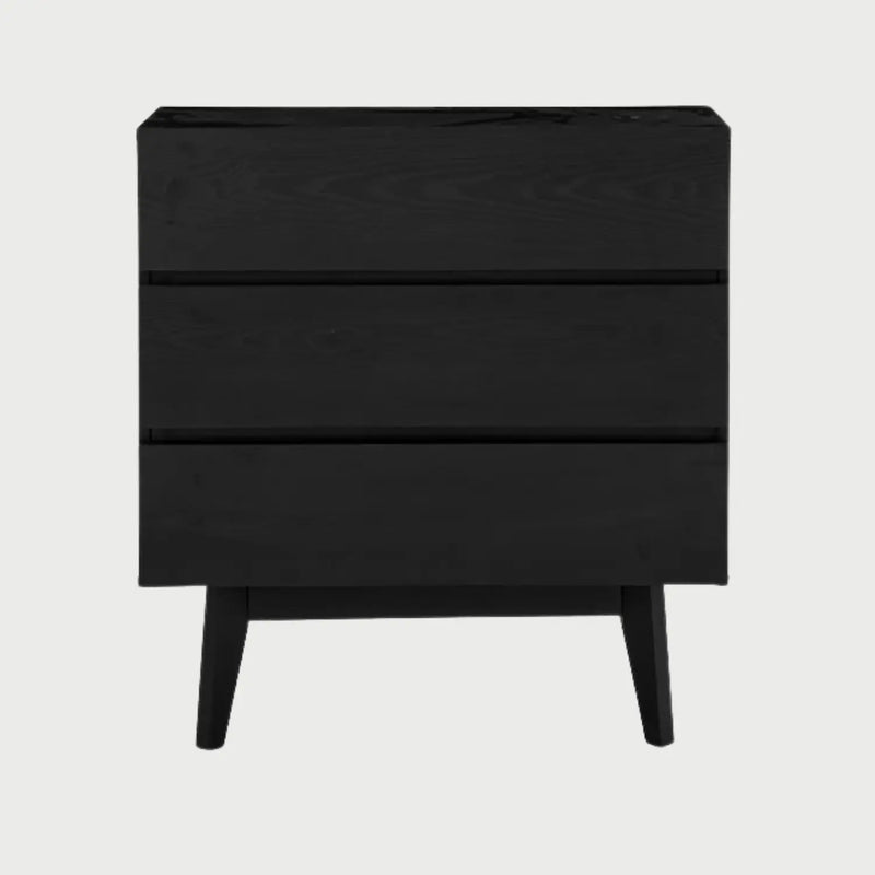 Vista frontal de la cómoda Meztli B en acabado negro mate, con tres cajones de frentes lisos, apertura integrada y patas de madera clara que contrastan con el cuerpo oscuro.