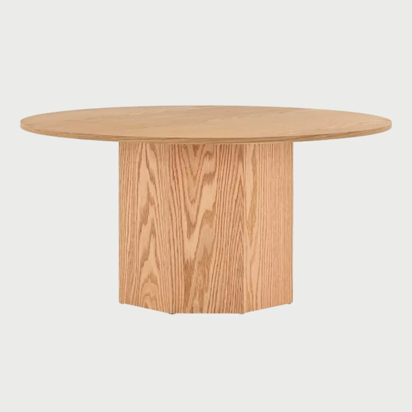 Vista frontal de la mesa de centro circular Aida en color beige encino; presenta una superficie redonda delgada soportada por una base cilíndrica central de gran volumen que muestra la veta natural de la madera.