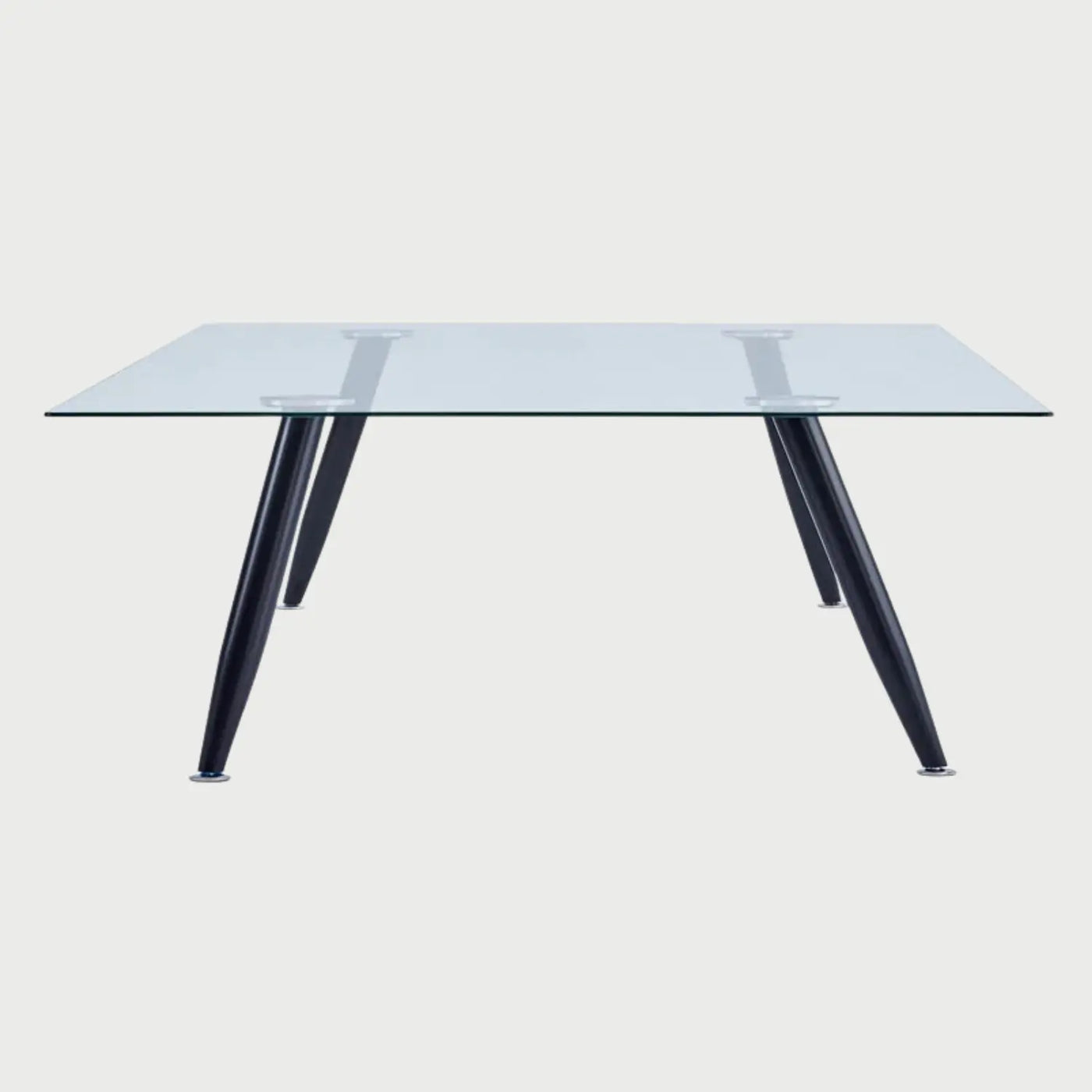 Vista frontal de la mesa de comedor Amit de 160 cm; presenta una superficie rectangular de cristal templado transparente apoyada sobre cuatro patas metálicas de color negro con diseño inclinado.
