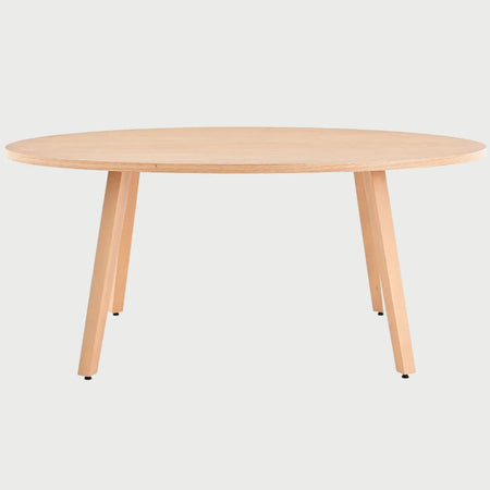 Vista frontal de la mesa de comedor ovalada Xocos en color beige encino; el acabado en madera clara realza las líneas curvas de la cubierta y la solidez de su estructura de soporte.