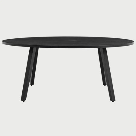 Vista frontal de la mesa de comedor ovalada Xocos en color negro; su acabado oscuro y monocromático enfatiza la silueta geométrica de las patas y la elegancia de la forma elíptica.