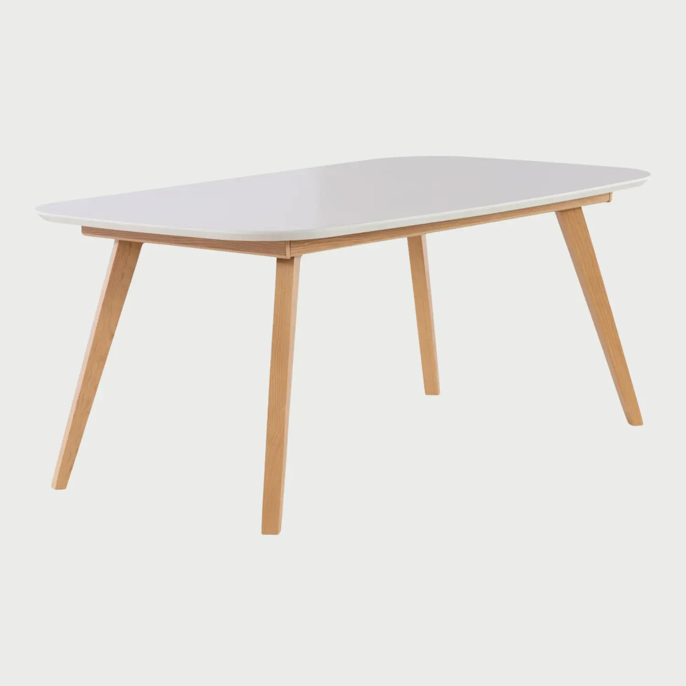 Vista lateral de la mesa Sei en color blanco; se aprecia la inclinación de las patas hacia afuera que maximiza el espacio inferior para los comensales y el perfil delgado de la cubierta de madera.