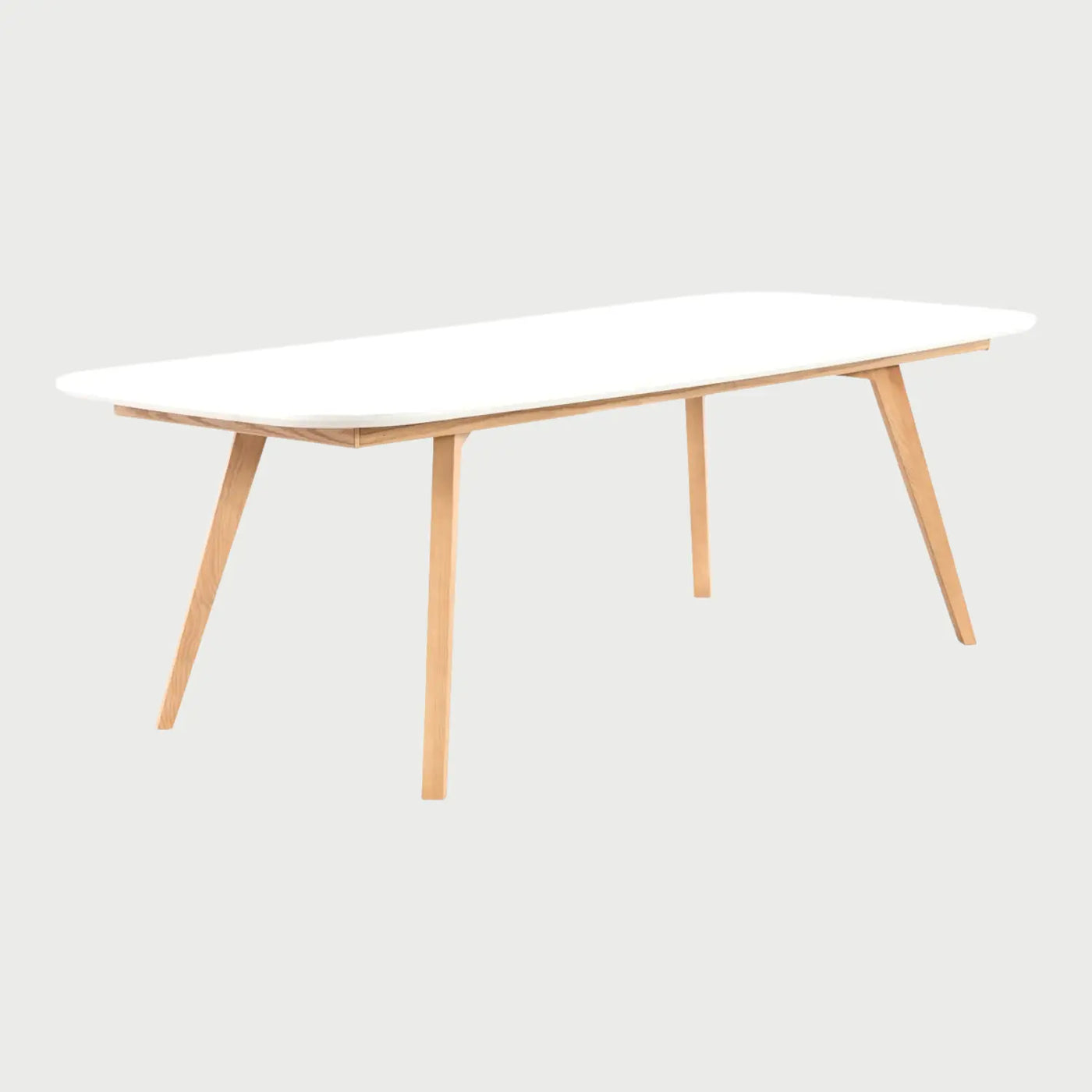 Vista lateral de la mesa Sei de 220 cm; destaca el perfil delgado de la cubierta blanca y la inclinación de las patas de madera que optimizan el espacio inferior para los comensales.