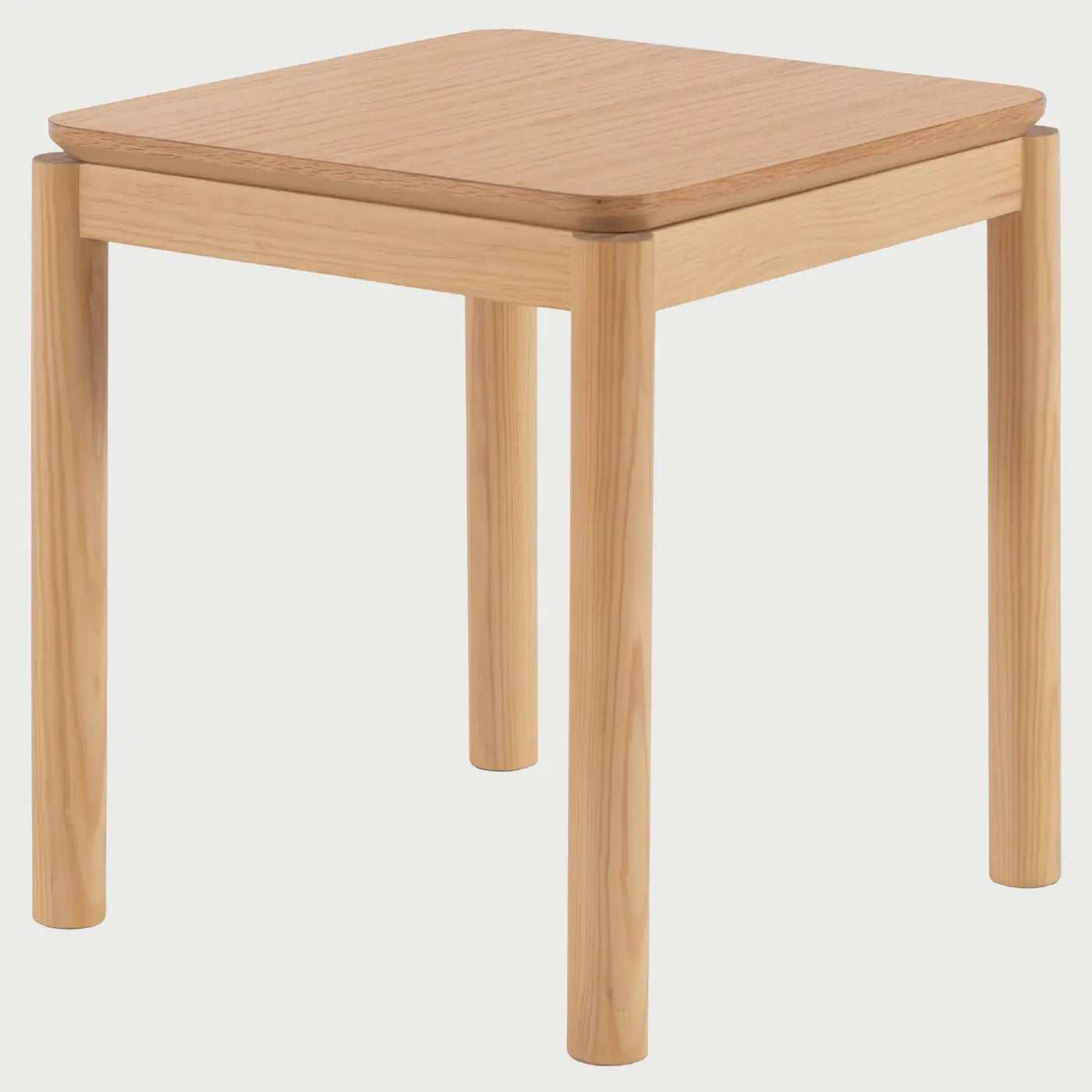 Vista de perfil de la mesa Akari; se observa el grosor de la cubierta y el ensamblaje limpio de las patas de madera, resaltando su silueta estable y de inspiración japonesa moderna.