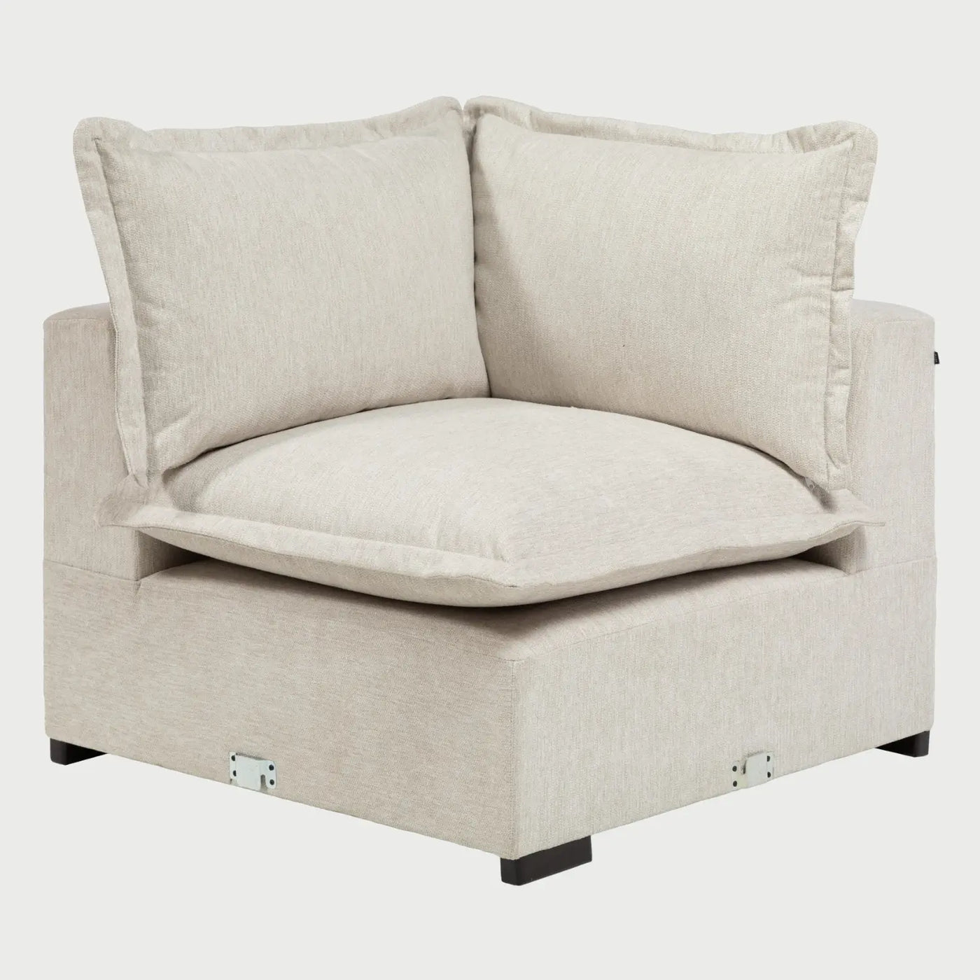 Vista frontal del módulo esquinero Emilia en color marfil; presenta una estética luminosa con grandes cojines de respaldo y patas cortas de madera oscura.