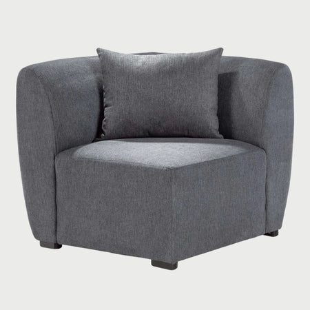 Vista frontal del módulo esquinero Kant GAIA tapizado en gris oscuro, resaltando el volumen de sus cojines y su estética contemporánea.