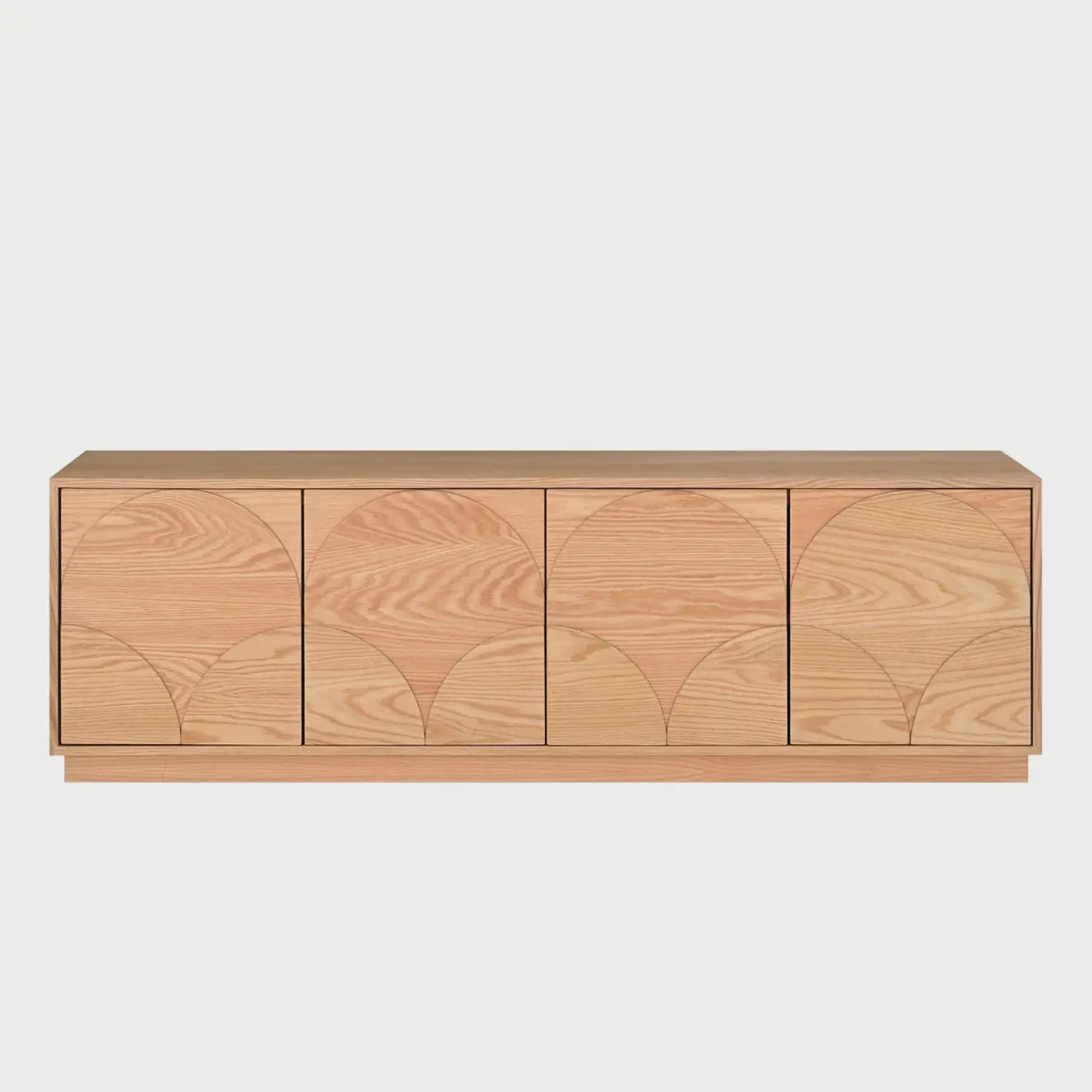 Vista frontal del mueble de TV Sasian de 160 cm en acabado beige encino, con cuatro frentes de almacenamiento que presentan un diseño grabado de arcos concéntricos y base de zócalo continuo.