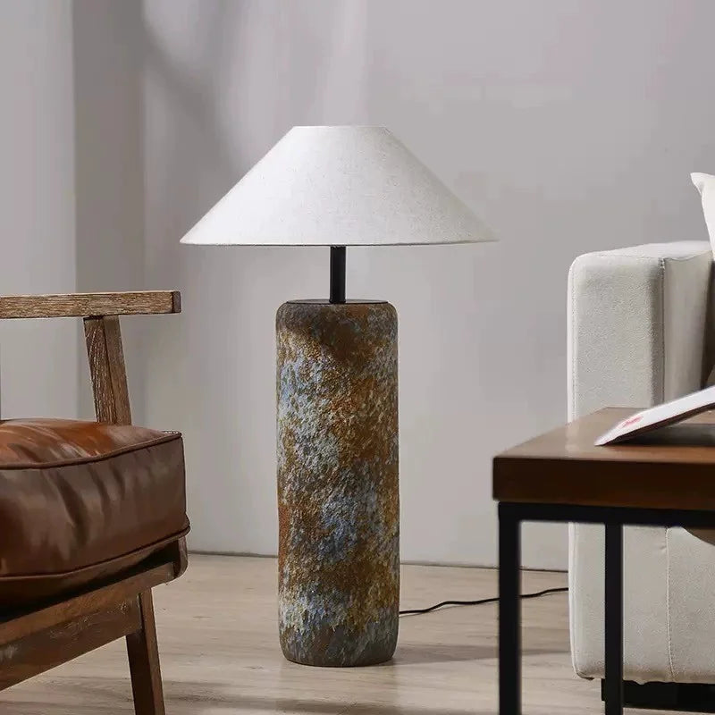 Lámpara de piso Colisio café ambientada en una sala de estar de diseño orgánico