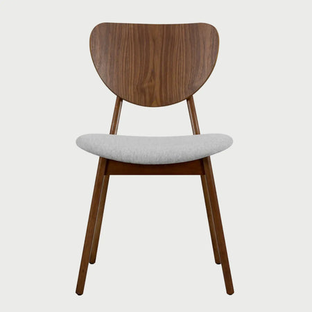 Vista frontal de la silla de comedor Naupan en color gris claro, resaltando el contraste luminoso entre el tapizado neutro y la estructura de madera oscura.