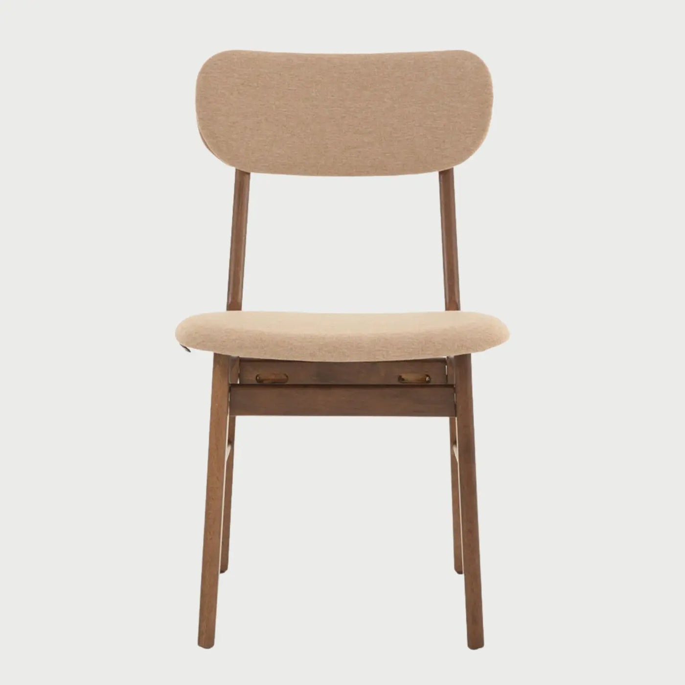 Vista frontal de la silla Marcela con estructura de madera en acabado nogal oscuro y asiento acolchado tapizado en tela beige; presenta un respaldo ovalado de madera contrachapada y patas cilíndricas.
