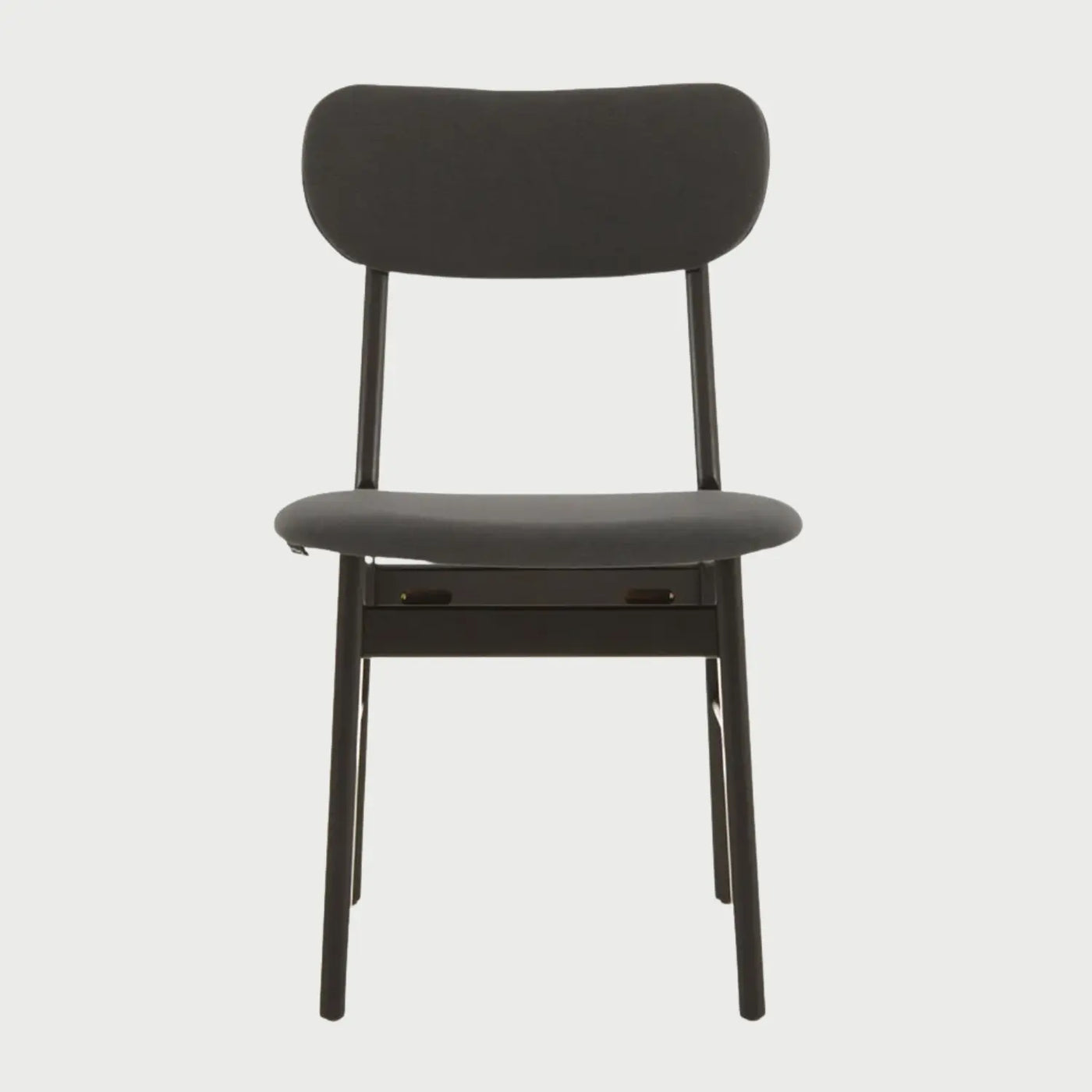 Vista frontal de la silla Marcela en color negro integral, con un respaldo ovalado horizontal, asiento acolchado tapizado y estructura de patas cilíndricas de madera en acabado negro mate.