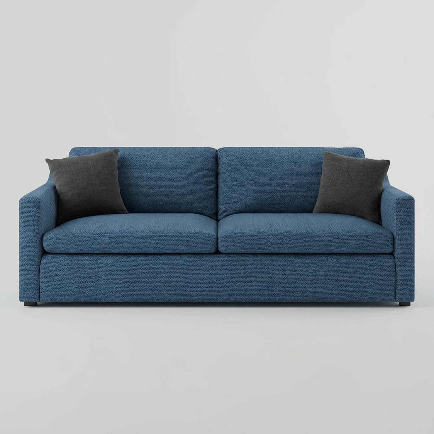Vista frontal del sillón Marie GAIA de tres cuerpos en tela azul, con un diseño contemporáneo de tres amplios cojines de asiento, respaldos mullidos y dos cojines decorativos en color gris oscuro.