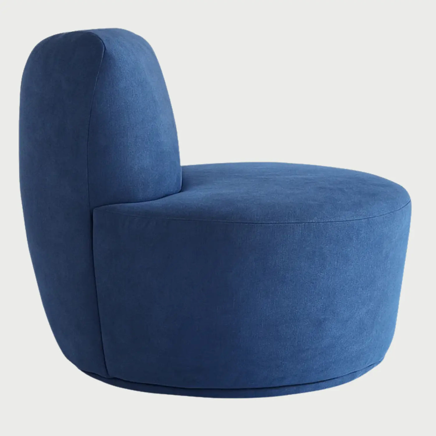 Vista lateral del sillón Sam GAIA en color azul, que muestra su diseño circular de una sola pieza, con un respaldo bajo redondeado y una base cilíndrica tapizada de estilo minimalista.