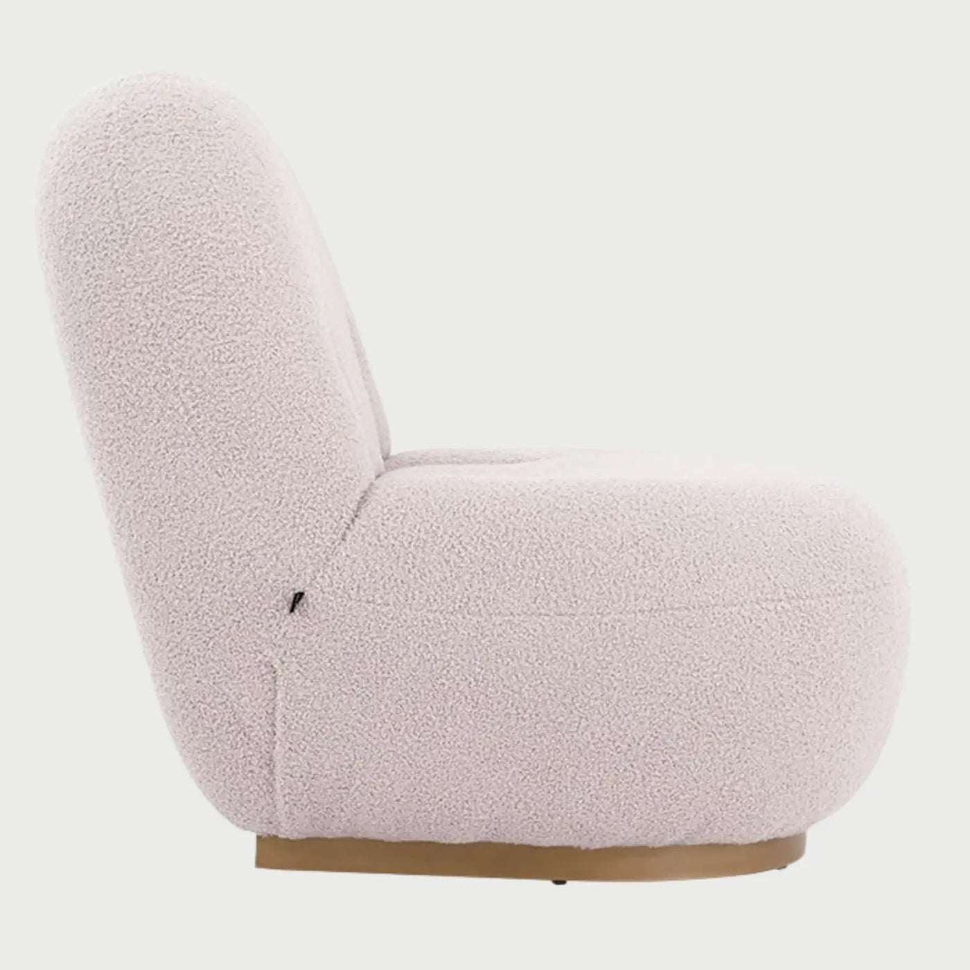 Vista lateral del sillón Toscana GAIA en tejido boucle blanco, mostrando su diseño orgánico de líneas curvas y una base de madera circular que aporta un toque cálido y moderno.