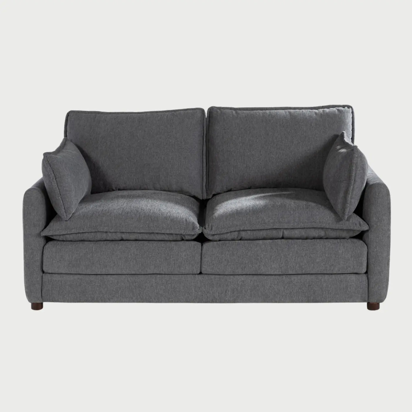 Vista frontal del sofá Andrea GAIA de dos cuerpos en tela gris, que muestra sus amplios cojines de asiento y respaldo tipo "puffy", descansabrazos rectos y patas de madera oscura.