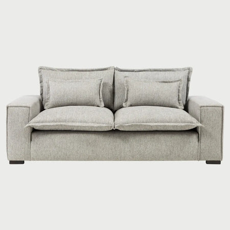 Vista frontal del sofá Emilia GAIA de dos cuerpos en tela gris, destacando su diseño extra ancho con cojines de asiento mullidos y dos juegos de cojines de respaldo superpuestos para un descanso superior.