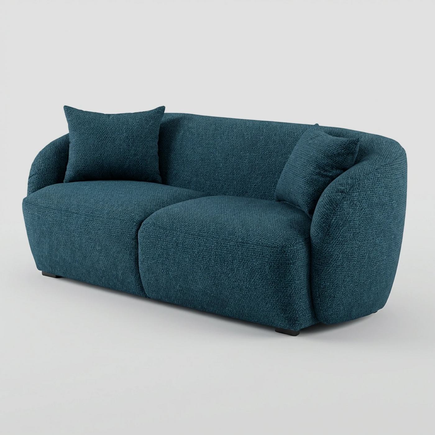 Vista lateral del sofá Kant azul de dos cuerpos, resaltando la suave curvatura del respaldo que se funde con los descansabrazos y su estructura de asiento profundo.