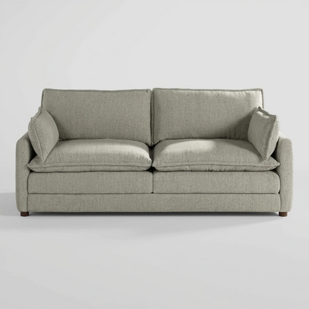 Vista frontal del sofá Andrea de tres cuerpos en color blanco, destacando su silueta robusta y la luminosidad de sus cojines de gran formato que ofrecen una apariencia acogedora.