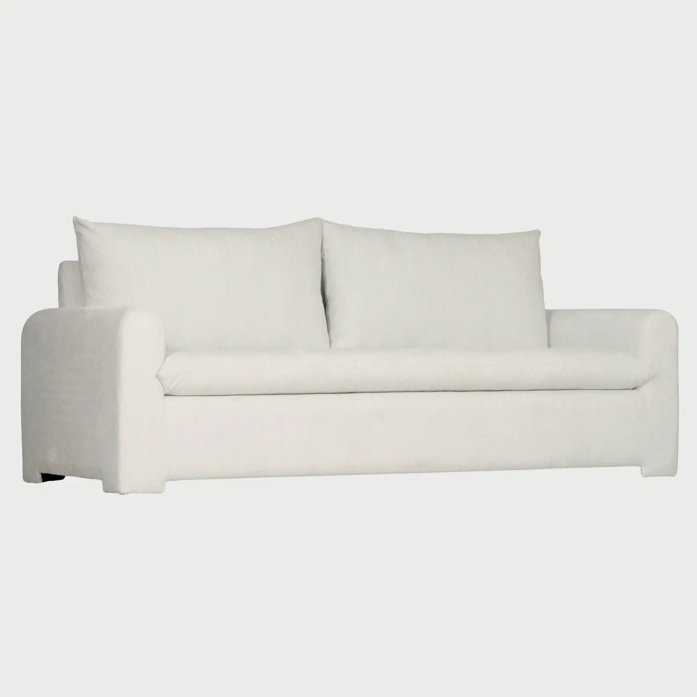 Vista lateral del sofá Ani de tres cuerpos en color blanco, destacando su perfil bajo y contemporáneo, con brazos anchos y rectos que se alinean con la base para una silueta limpia.