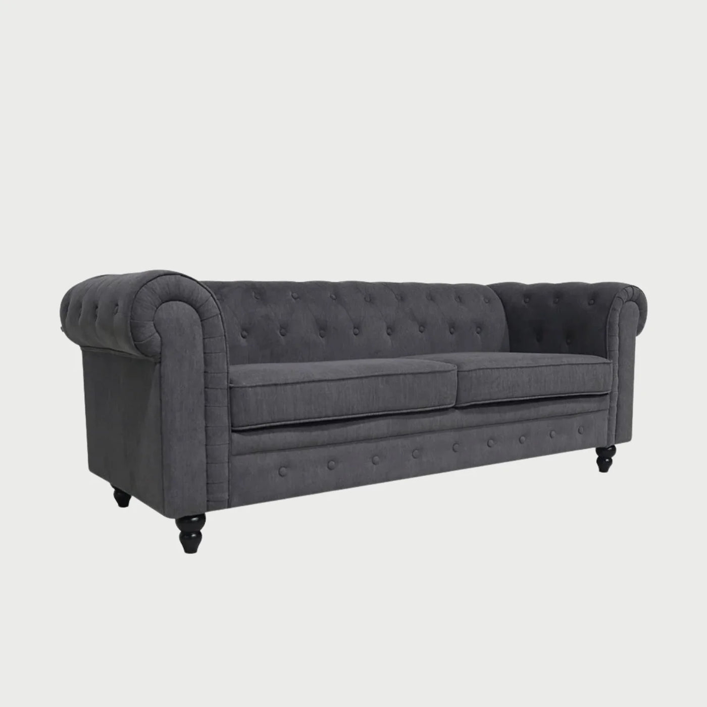 Vista lateral del sofá Chesterfield Bogar gris oscuro, destacando el brazo enrollado y diseño clásico