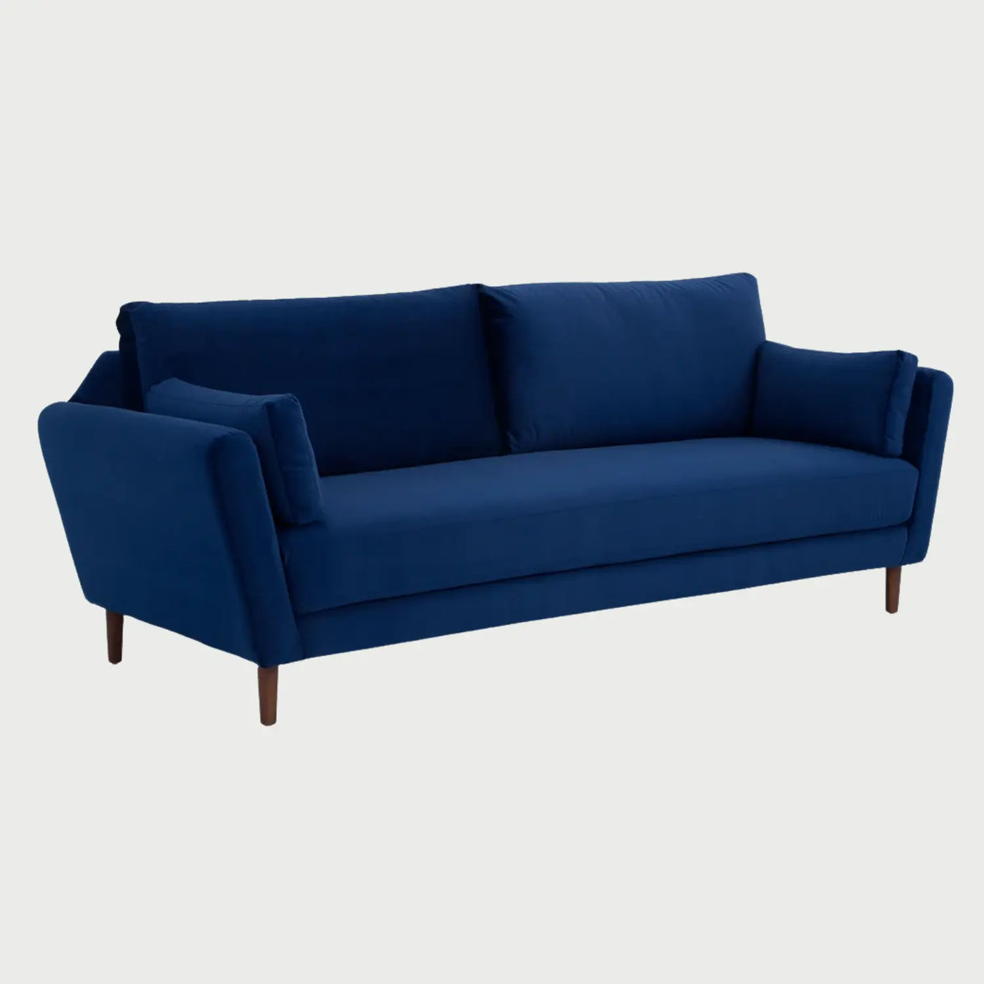 Vista lateral del sofá Levanto azul, resaltando la inclinación de los descansabrazos y el soporte de las patas de madera nogal que aportan un contraste sofisticado al tono azul.