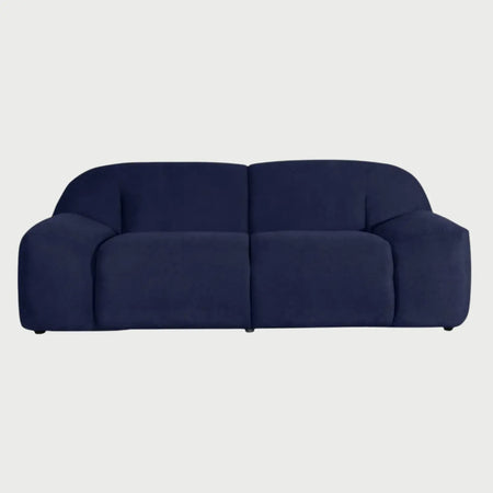 Vista frontal del sofá Marcus GAIA de tres cuerpos en tela azul marino, destacando su diseño robusto de bloques con asientos profundos, respaldos curvos y brazos anchos integrados que llegan hasta el suelo.