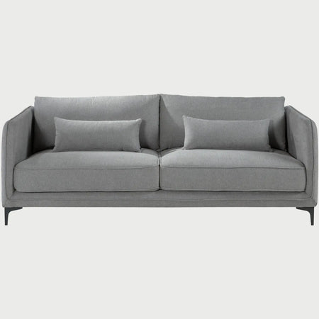 Vista frontal del sofá Marina de tres cuerpos en color gris, resaltando el equilibrio visual de sus tres plazas y sus descansabrazos de diseño lineal con cojines de apoyo.