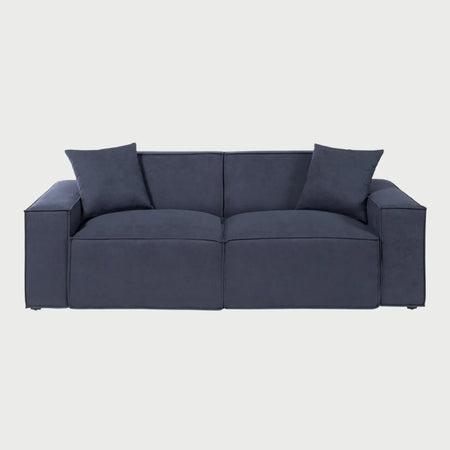 Vista frontal del sofá Otto GAIA de tres cuerpos en tela azul, con un diseño modular de líneas rectas, dos grandes cojines de asiento y respaldo con costuras de pestaña acentuadas, y dos cojines decorativos cuadrados a juego.