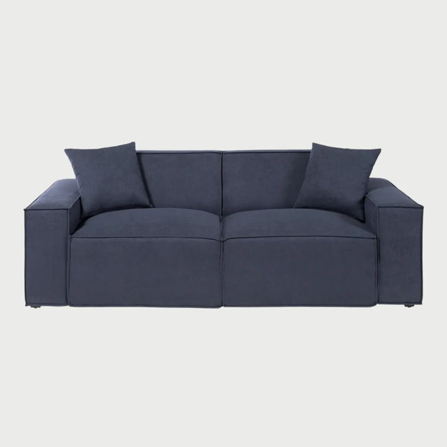 Vista frontal del sofá Otto GAIA de tres cuerpos en tela azul, con un diseño modular de líneas rectas, dos grandes cojines de asiento y respaldo con costuras de pestaña acentuadas, y dos cojines decorativos cuadrados a juego.